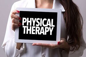 Women holding a sign saying Physical Therapy